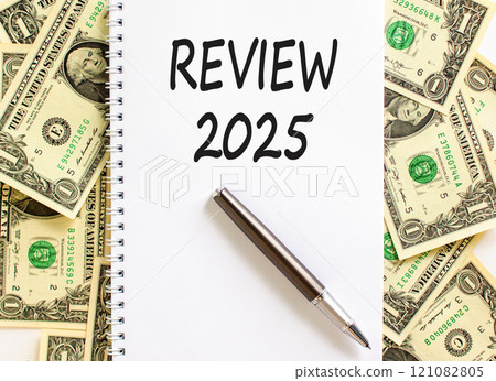 Planning review 2025 new year symbol. Concept words Review 2025 on beautiful white note. Beautiful background from dollar bills. Black pen. Business review 2025 new year concept. Copy space. Planning review 2025 new year symbol. Concept words Review 2025 on beautiful white note. Beautiful background from dollar bills. Black pen. Business review 2025 new year concept. Copy space. 121082805