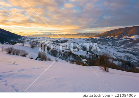 rural mountain landscape in winter at sunrise. snow covered hills in morning light 121084009