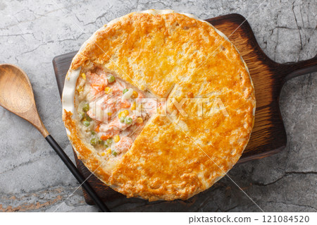 Homemade Salmon Pot Pie with carrots, corn, onion and peas and in a buttery pie crust closeup on the baking dish. Horizontal top view Homemade Salmon Pot Pie with carrots, corn, onion and peas and in a buttery pie crust closeup on the baking dish. Horizontal top view 121084520
