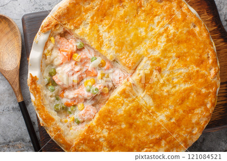 Tasty creamy salmon vegetables pot pie with crispy puff crust closeup on the baking dish. Horizontal top view Tasty creamy salmon vegetables pot pie with crispy puff crust closeup on the baking dish. Horizontal top view 121084521