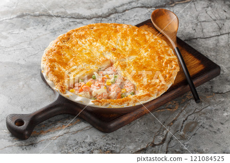 Festive fish Pot Pie with salmon, carrots, corn, onion and peas and in a buttery pie crust closeup on the baking dish. Horizontal Festive fish Pot Pie with salmon, carrots, corn, onion and peas and in a buttery pie crust closeup on the baking dish. Horizontal 121084525
