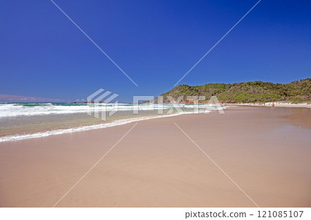 Wide sandy beach on the Golden Coast, Australia, with clear blue skies and gentle ocean waves 121085107
