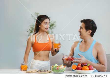 Fit Smiling couple enjoys healthy fruit breakfast. Fit Smiling couple enjoys healthy fruit breakfast. 121085741