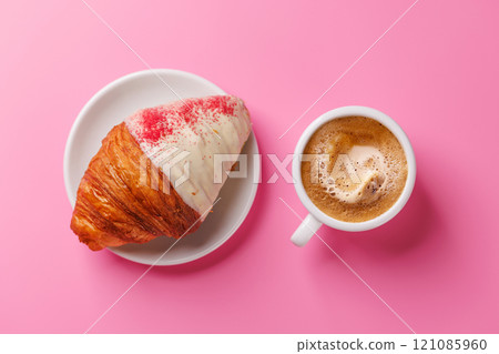 A delightful pairing of a freshly brewed coffee and a raspberry croissant 121085960