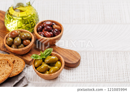 An assortment of various olives presented in a bowl, showcasing different colors, textures, and flavors An assortment of various olives presented in a bowl, showcasing different colors, textures, and flavors 121085994