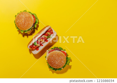 A vibrant photo showcasing juicy cheeseburgers and hot dog 121086034