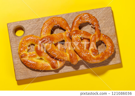 Pretzels scattered across a bright yellow background Pretzels scattered across a bright yellow background 121086036