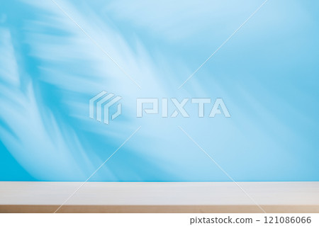 Template with empty table and wall with natural plant shadow and sunny glare 121086066