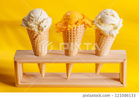 A refreshing ice cream cones set against a vibrant yellow background 121086133