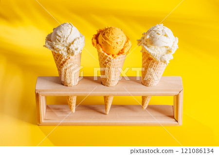 A refreshing ice cream cones set against a vibrant yellow background A refreshing ice cream cones set against a vibrant yellow background 121086134