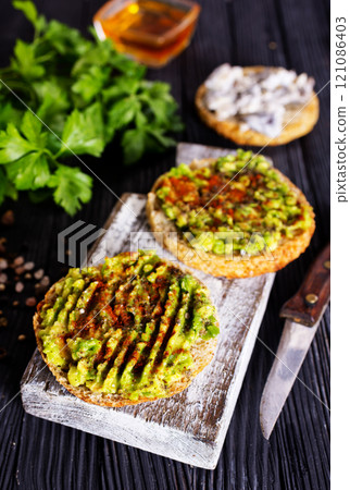 Fresh sandwich with avocado and herbs and seeds 121086403