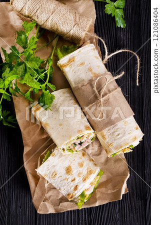 Shawarma sandwich, fresh roll of lavash (pita bread) pork shawarma with ham and cheese Shawarma sandwich, fresh roll of lavash (pita bread) pork shawarma with ham and cheese 121086404