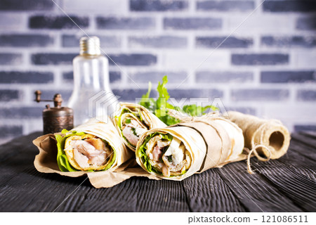 Shawarma sandwich, fresh roll of lavash (pita bread) pork shawarma with ham and cheese 121086511