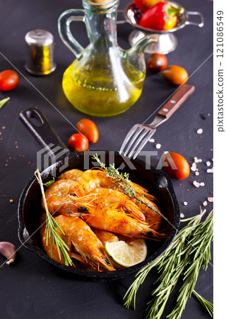 Grilled shrimps with greens and garlic in a pan Grilled shrimps with greens and garlic in a pan 121086549