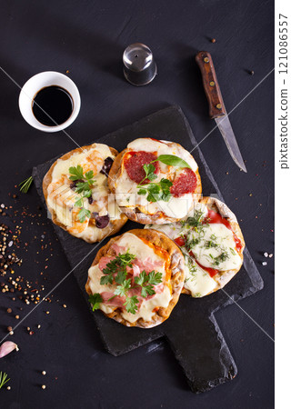 Mini pizzas - pizzette - topped with cheese and tomato, pizza with seafood Mini pizzas - pizzette - topped with cheese and tomato, pizza with seafood 121086557