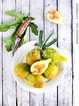 Fresh figs on plate on wooden table. Fresh figs on plate on wooden table. 121086668