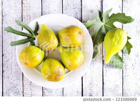 Fresh figs on plate on wooden table. Fresh figs on plate on wooden table. 121086669