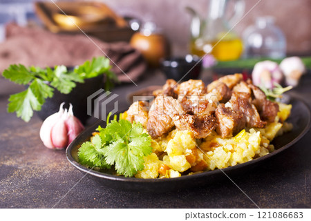 Uzbek food pilaf in iron pan. 121086683