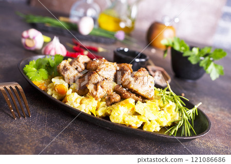 Uzbek food pilaf in iron pan. 121086686
