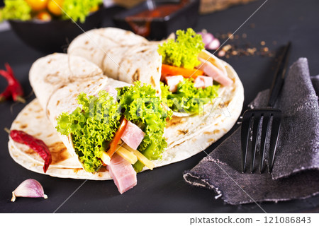 Shawarma sandwich, fresh roll of lavash (pita bread) pork shawarma with ham and cheese 121086843