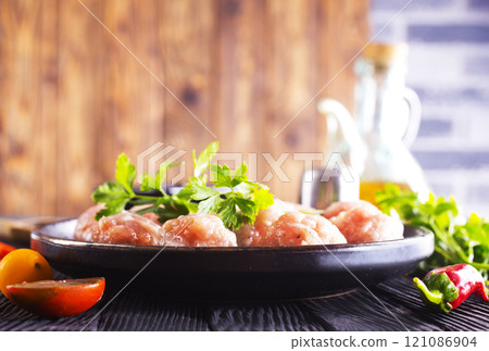Raw meatballs on plate on a table, close up Raw meatballs on plate on a table, close up 121086904