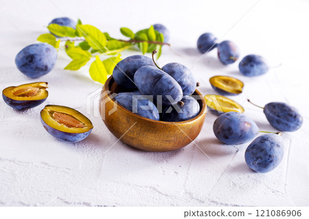 fresh ripe plums on light background 121086906