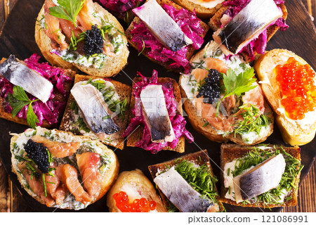 Cocktail canapes with herring, cream cheese and caviar on rye bread Cocktail canapes with herring, cream cheese and caviar on rye bread 121086991