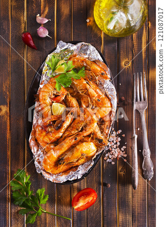 Roast Prawns Shrimps in a pan with herbs and garlic. Dark wooden background. 121087017