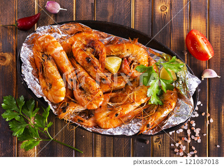 Roast Prawns Shrimps in a pan with herbs and garlic. Dark wooden background. Roast Prawns Shrimps in a pan with herbs and garlic. Dark wooden background. 121087018
