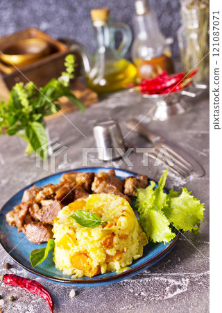 boiled rice with fried meat on plate 121087071