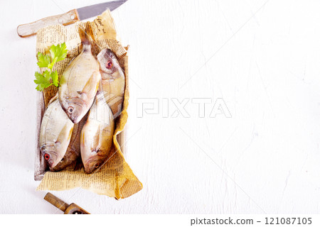 Raw fish on paper on a table Raw fish on paper on a table 121087105