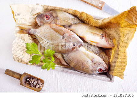 Raw fish on paper on a table 121087106