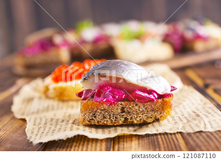 Cocktail canapes with smoked salmon, herring, cream cheese and caviar on rye bread - gourmet party food. Cocktail canapes with smoked salmon, herring, cream cheese and caviar on rye bread - gourmet party food. 121087110