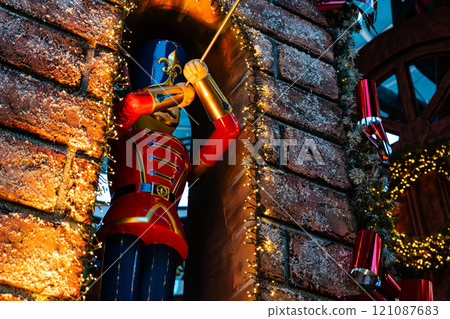 A big nutcracker plays music on a trumpet, a street Christmas toy 121087683