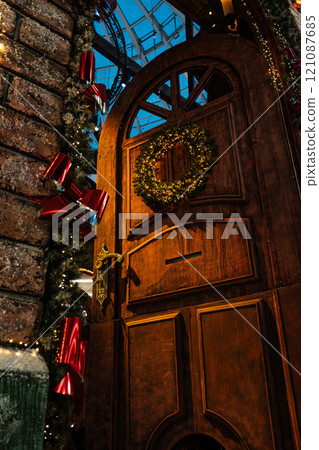 The huge door is decorated with a Christmas wreath. New Year's background 121087685