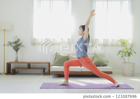 一個女人在客廳做瑜伽 121087696
