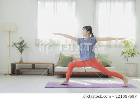 一個女人在客廳做瑜伽 121087697
