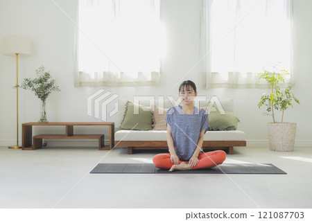 一個女人在客廳做瑜伽 一個女人在客廳做瑜伽 121087703