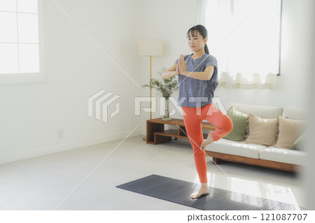 一個女人在客廳做瑜伽 121087707