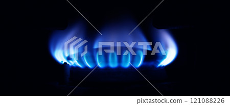 Gas stove burning in the kitchen, blue flames black background Gas stove burning in the kitchen, blue flames black background 121088226