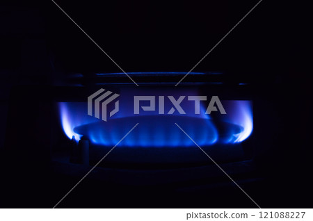 Gas stove burning in the kitchen, blue flames black background Gas stove burning in the kitchen, blue flames black background 121088227