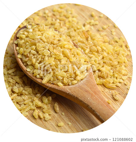 Cracked wheat daliya grains in wooden spoon, on bamboo cutting board Cracked wheat daliya grains in wooden spoon, on bamboo cutting board 121088602
