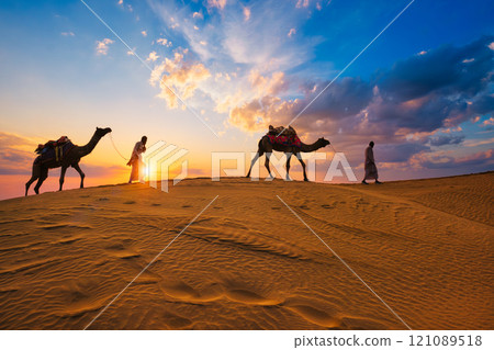 Indian cameleers camel drivers camel silhouettes in dunes on sunset. Jaisalmer, Rajasthan, India 121089518
