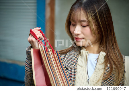 穿著冬衣、提著購物袋的女人 121090047