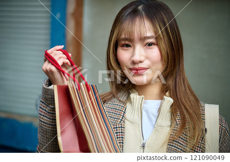 穿著冬衣、提著購物袋的女人 121090049