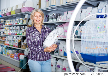 Woman buying pet food in shop for animal Woman buying pet food in shop for animal 121090453