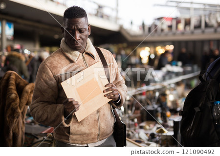 Man looks at antiques at a flea market Man looks at antiques at a flea market 121090492
