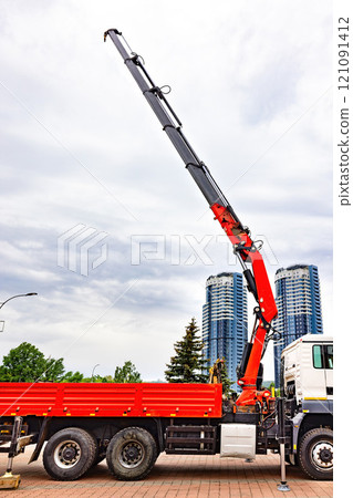 Towering crane reaches towards the cloudy sky above a busy urban construction site 121091412