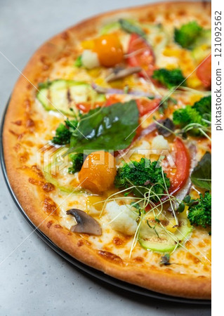 Delicious vegetarian pizza lying on table in restaurant Delicious vegetarian pizza lying on table in restaurant 121092562