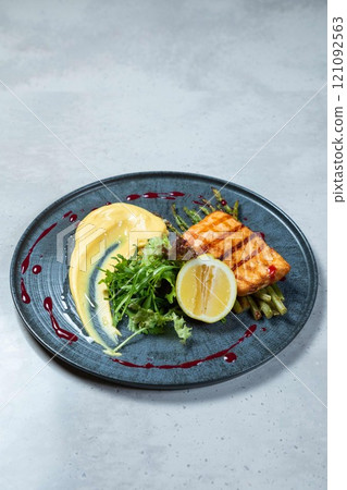 Grilled salmon fillet served with asparagus and mashed potatoes on elegant restaurant plate Grilled salmon fillet served with asparagus and mashed potatoes on elegant restaurant plate 121092563